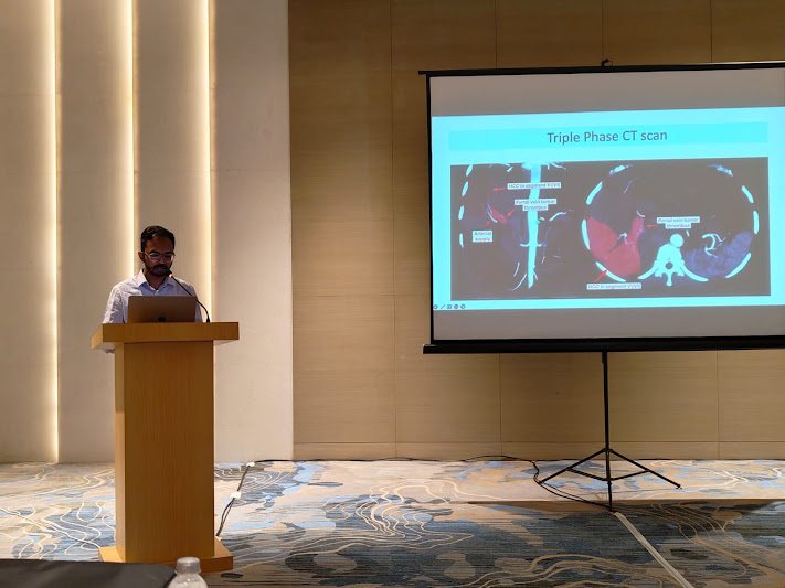 Dr. Bhaskar Das presenting a triple-phase CT scan at a teaching session